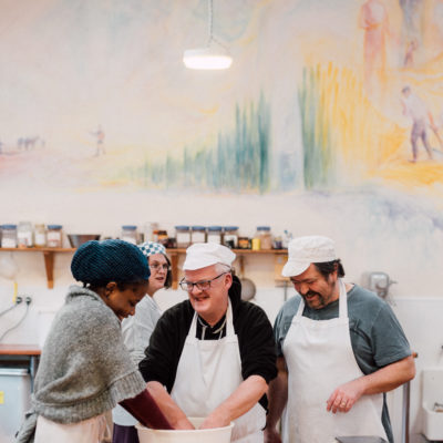 3 people cooking together in a kitchen, laughing