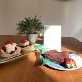 Scones with cream and jam and chocolate cake and strawberries