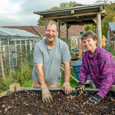 Two people gardening and smiling
